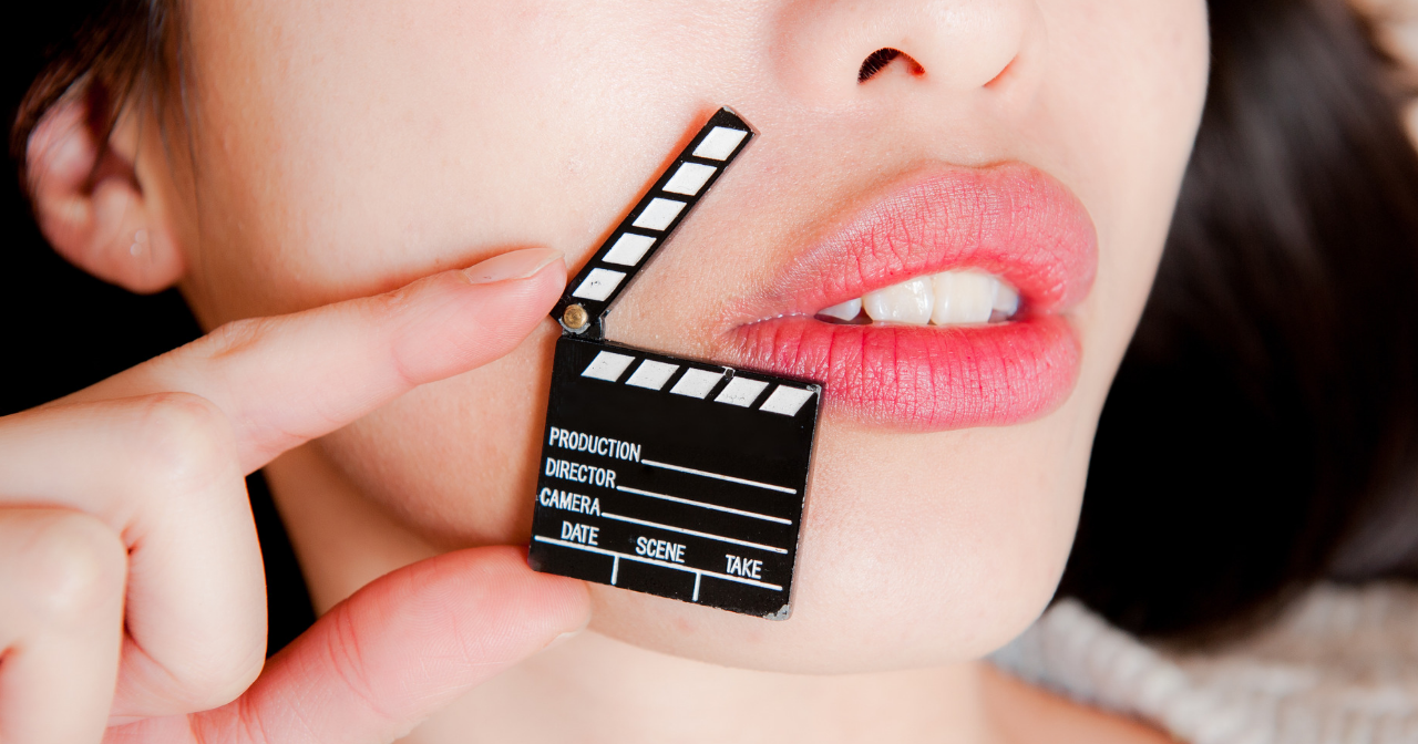 A black and white movie clapper next to a woman's lips
