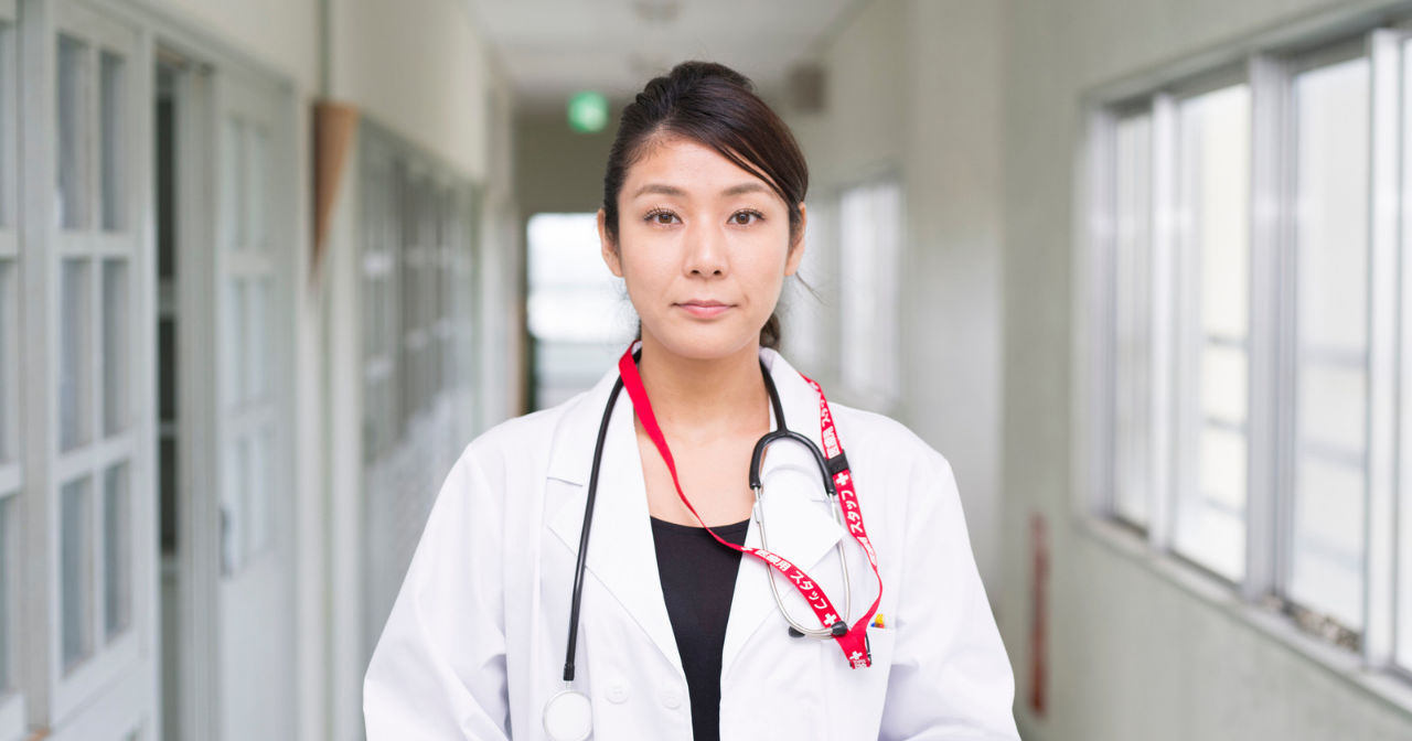 An Asian American doctor looks straight into the camera