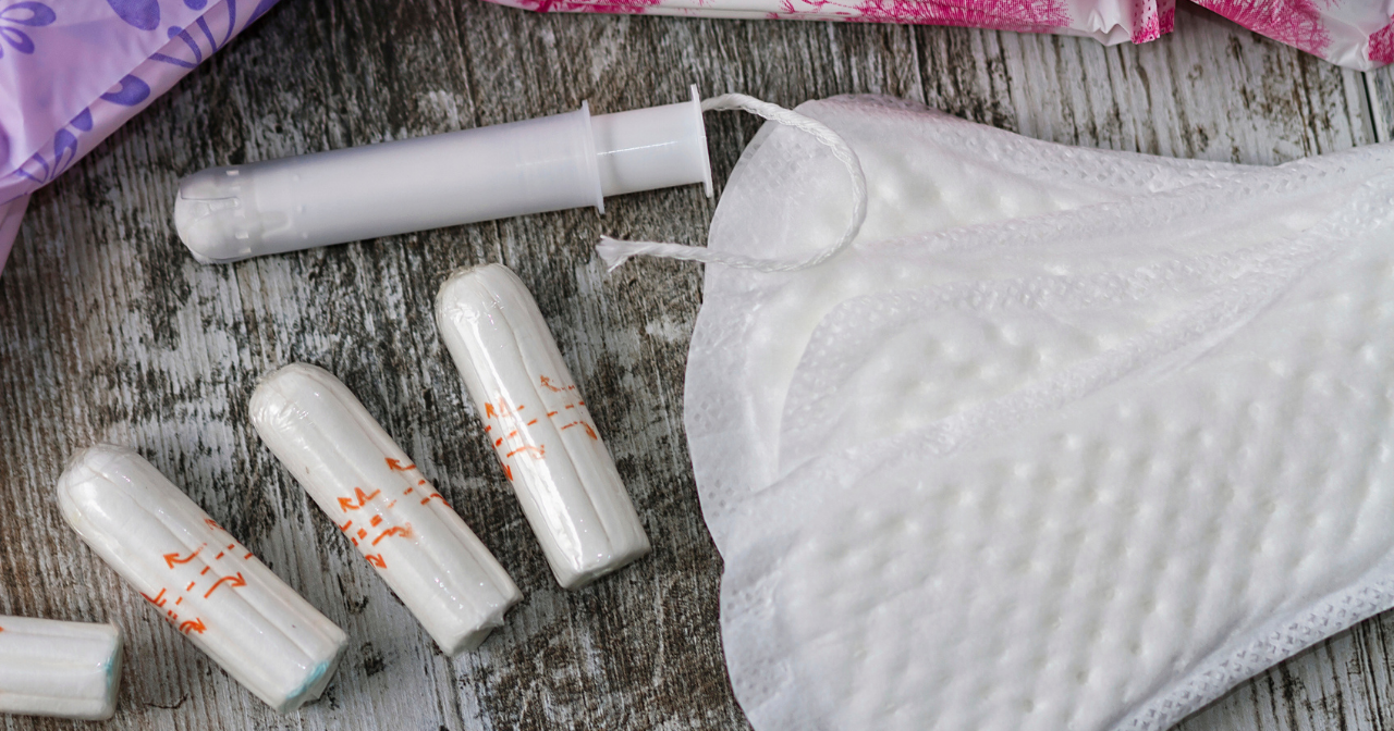 A selection of pads and tampons spread across a table.