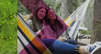 two women in a hammock, smiling