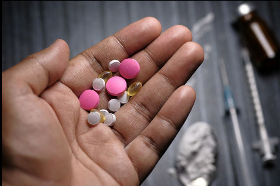 A hand with a lot of pills in the palm