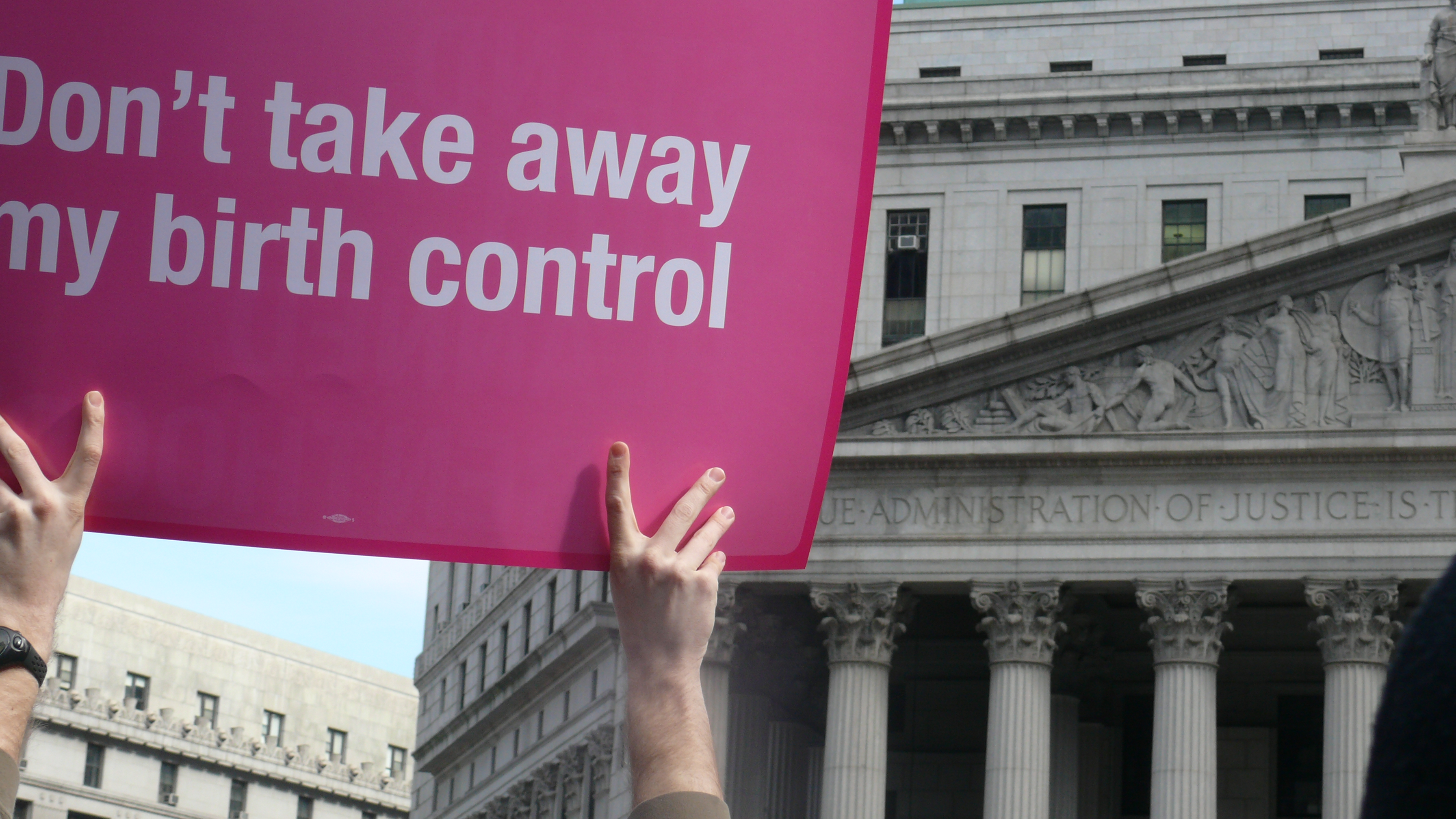 a woman holding a sign that reads, "Don't take away my birth control"