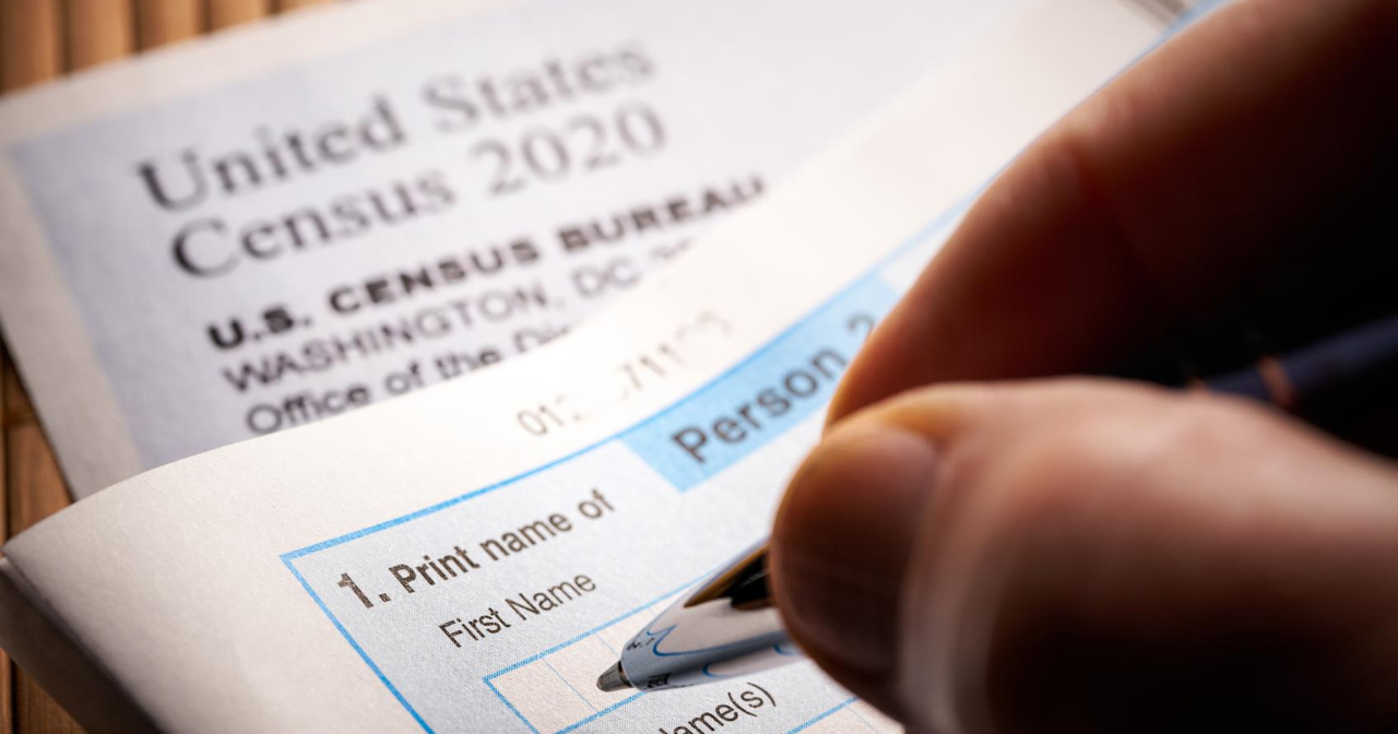 A hand holding a pen fills out the 2020 Census 