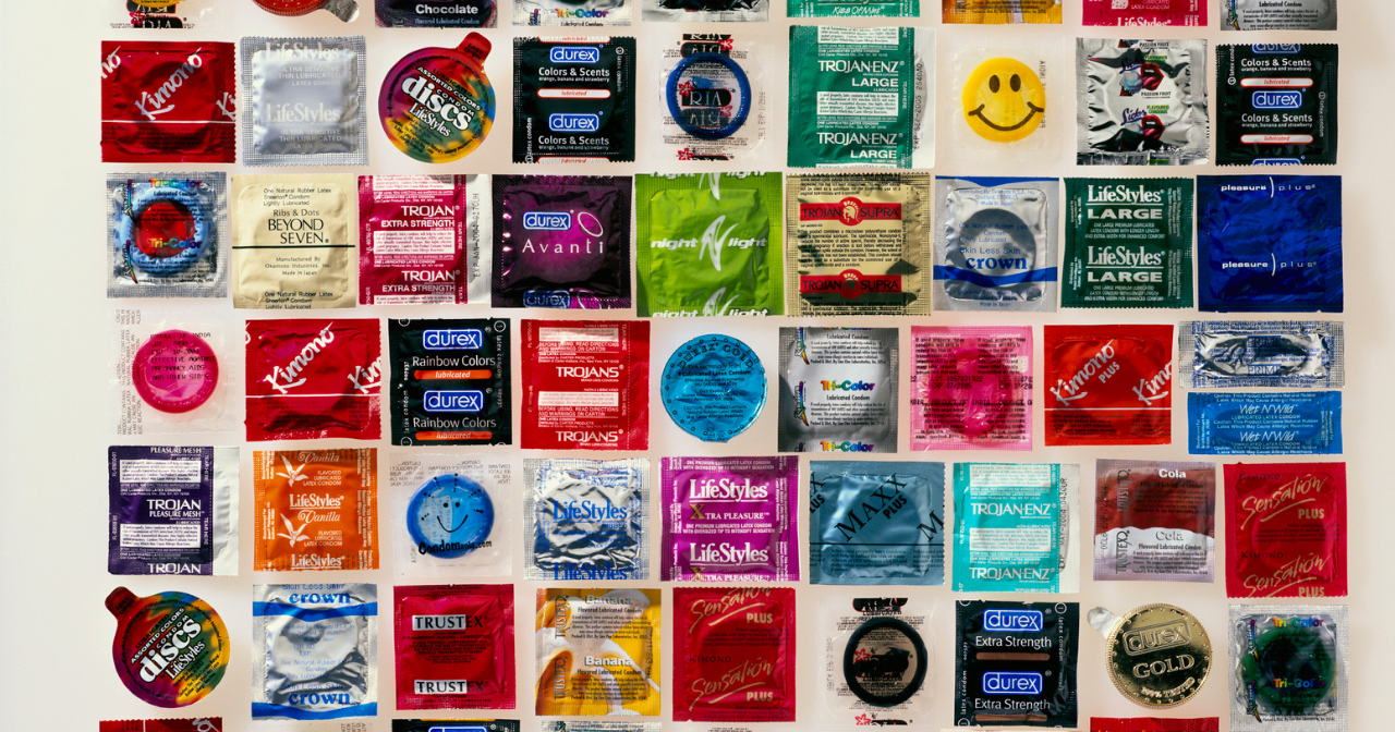 Rows and rows of condoms in their wrappers laid out on a table. 