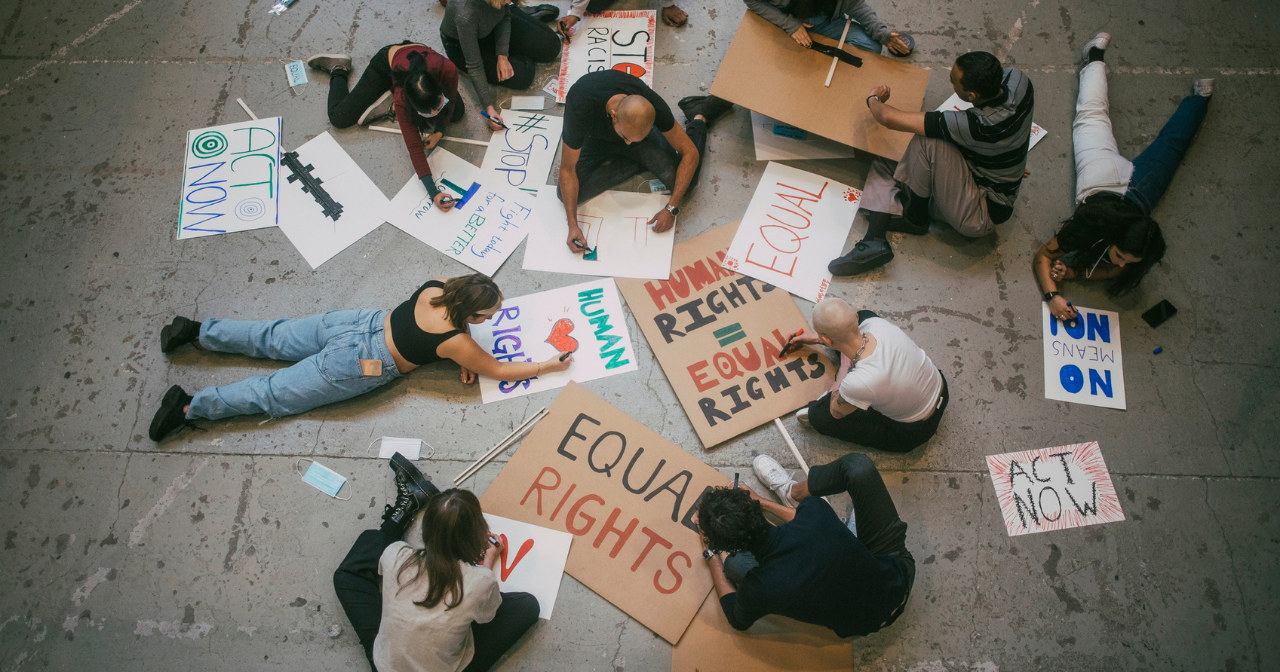 A group of people write out protest signs. 