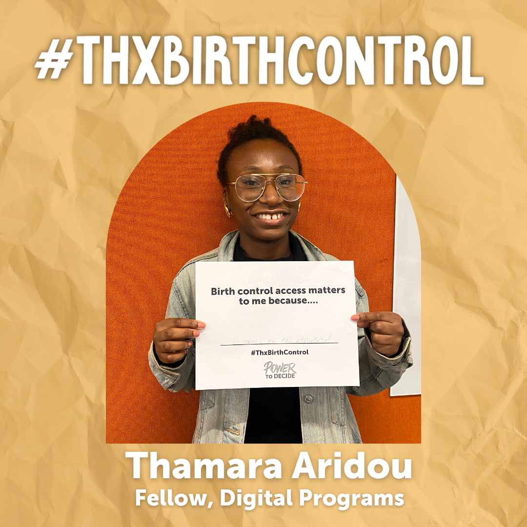 A Power to Decide Staffer holds a sign with their reason for saying #ThxBirthControl.