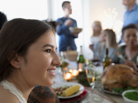 a young woman sits at a holiday table with a smile
