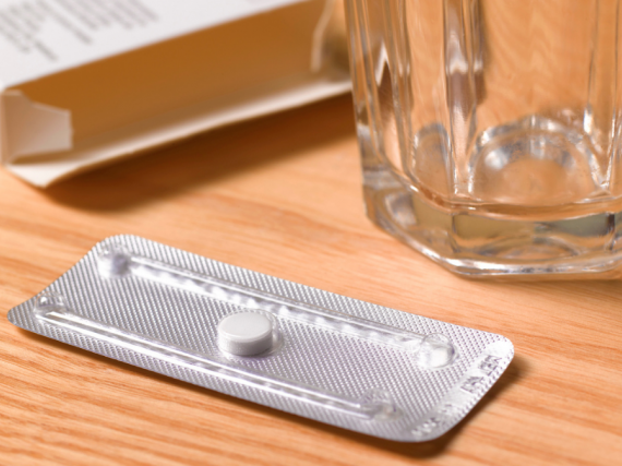 An image of an emergency contraceptive pill and a glass of water. 