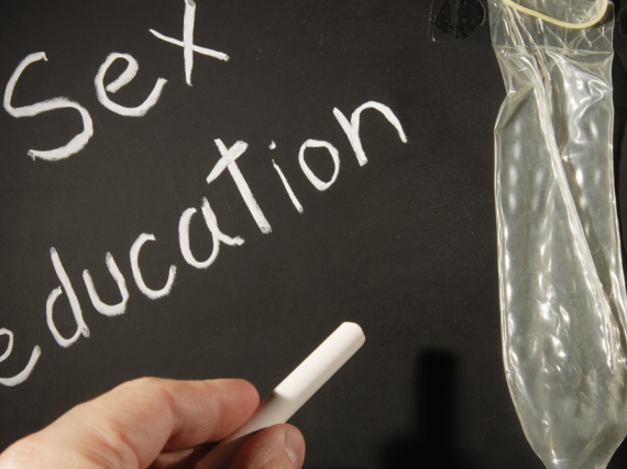 A chalkboard with the words sex education and a condom. 