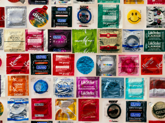 Rows and rows of condoms in their wrappers laid out on a table. 
