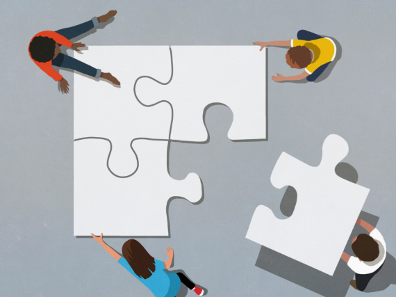 An illustration of four people with human sized puzzle pieces working together to put them together. 