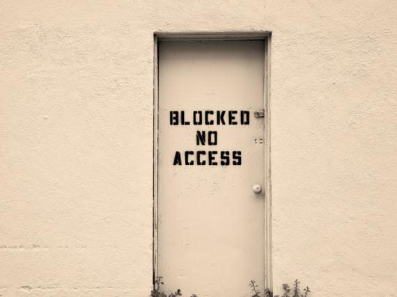 An image of a door with the words, "Blocked No Access" spray painted on it. 
