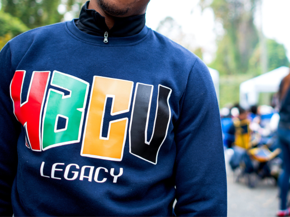 A close up image of a man in a blue sweatshirt with the words "HBCU Legacy."