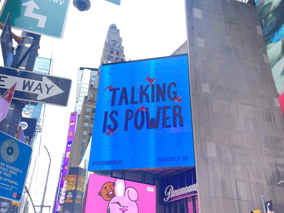 A photo of a Times Square NYC billboard that reads, "Talking is Power."